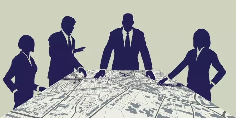 Vector image of men and women city planners dark silhouettes working over a city planning map.
